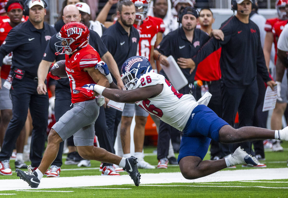 UNLV wide receiver Jacob De Jesus (21) is driven out of bounds by Fresno State Bulldogs linebac ...