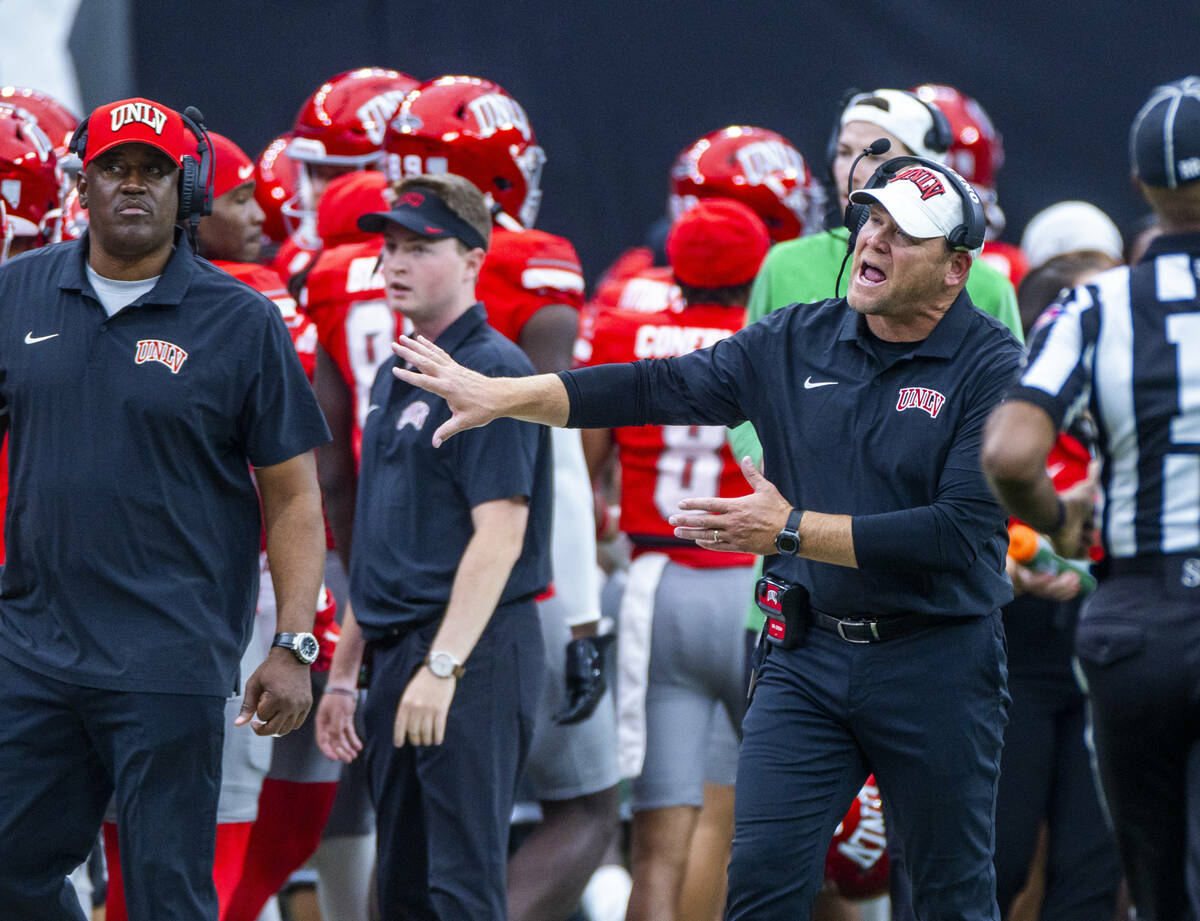 UNLV Head Coach Barry Odom keeps his players in check after a score against the Fresno State Bu ...