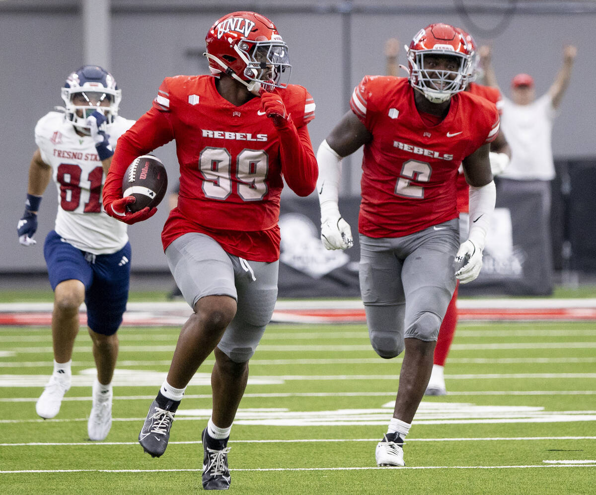 UNLV defensive lineman Keith Conley Jr. (99) runs with teammates toward the end zone after scoo ...