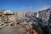 People gather at the site of the assassination of Hezbollah leader Hassan Nasrallah in Beirut's ...