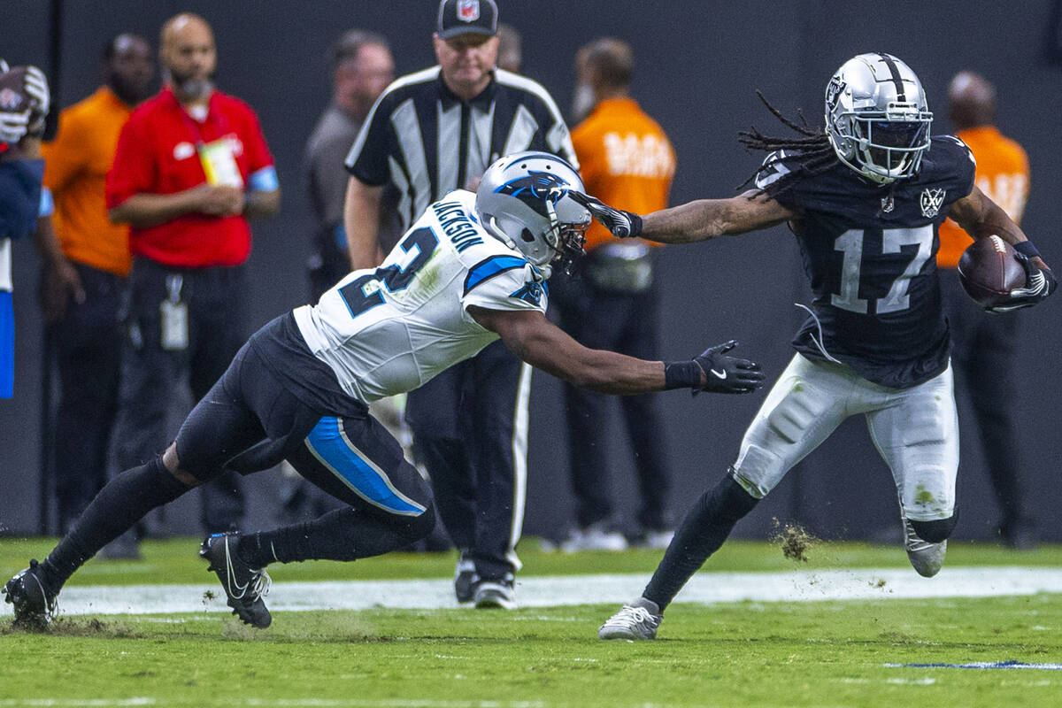 Raiders wide receiver Davante Adams (17) evades a tackle attempt by Carolina Panthers cornerbac ...