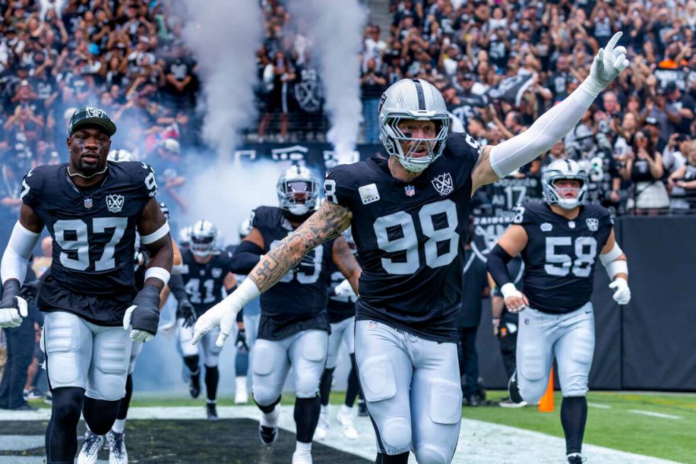 Raiders defensive end Maxx Crosby (98) leads his teammates onto the field before the first half ...