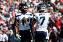 Seattle Seahawks wide receiver DK Metcalf, left, smiles at quarterback Geno Smith during an NFL ...