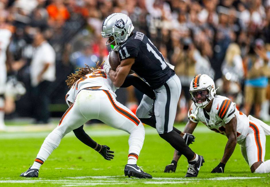 Raiders wide receiver Tre Tucker (11) looks to break a tackle by Cleveland Browns safety Ronnie ...