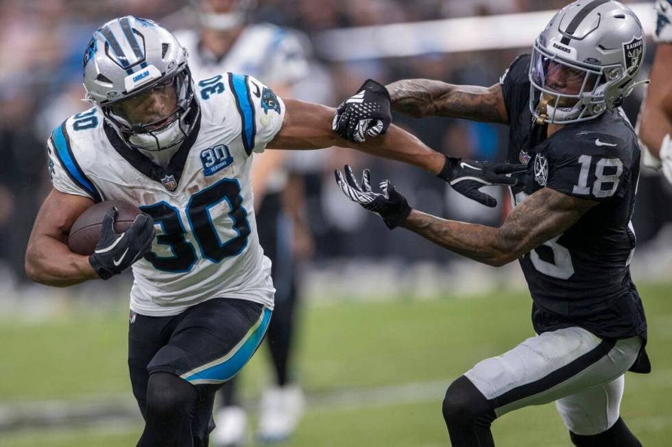 Carolina Panthers running back Chuba Hubbard (30) runs past Raiders cornerback Jack Jones (18) ...