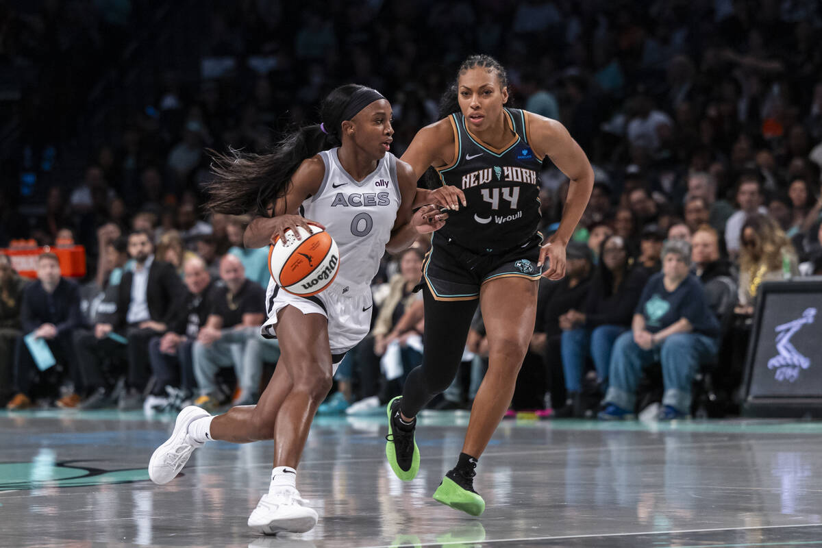 Las Vegas Aces guard Jackie Young (0) drives around New York Liberty forward Betnijah Laney-Ham ...