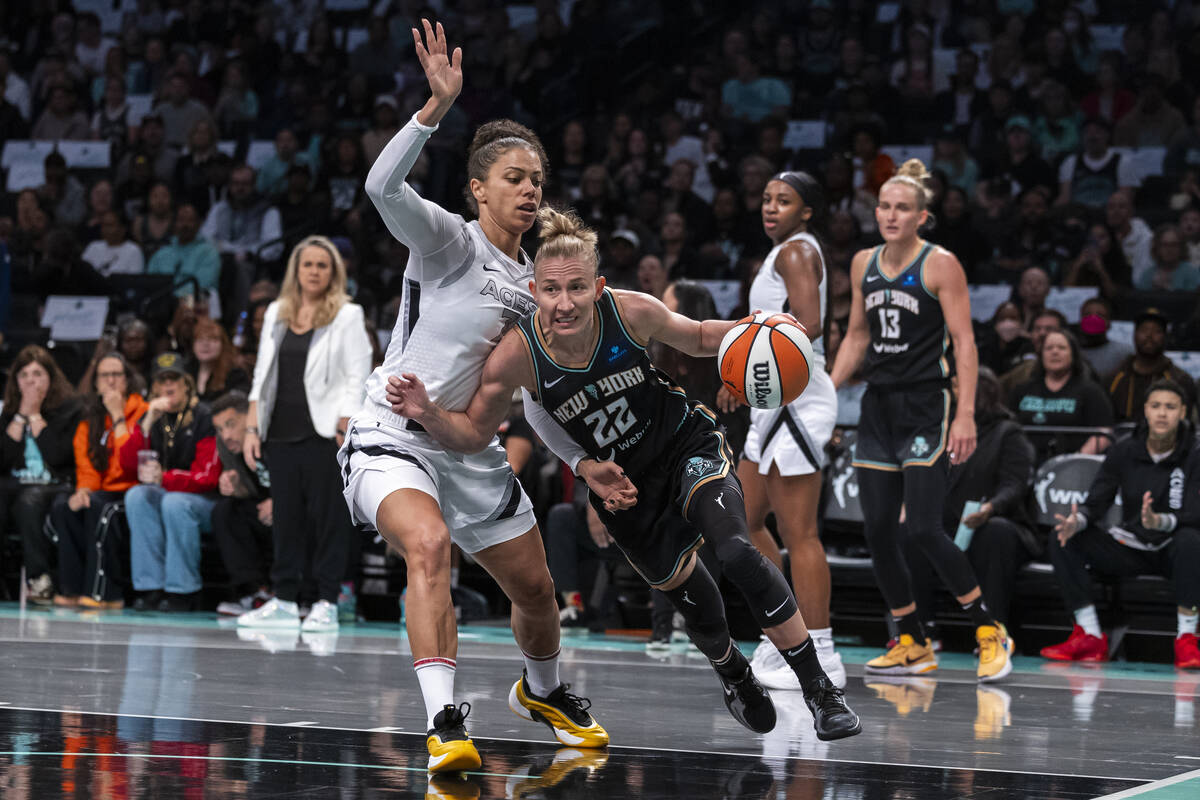 New York Liberty guard Courtney Vandersloot (22) is defended by Las Vegas Aces forward Alysha C ...