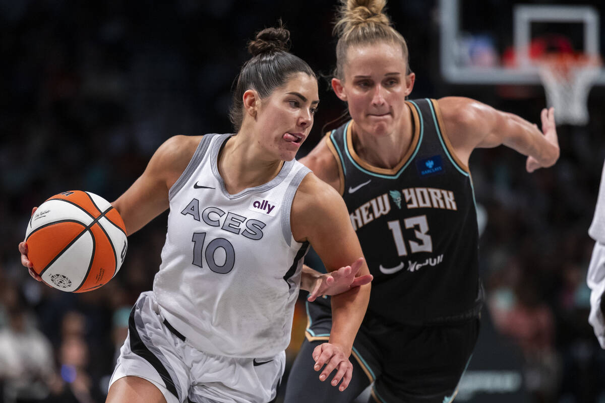 Las Vegas Aces guard Kelsey Plum (10) drives past New York Liberty forward Leonie Fiebich (13) ...