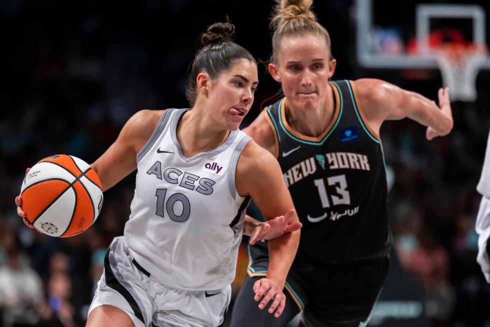 Las Vegas Aces guard Kelsey Plum (10) drives past New York Liberty forward Leonie Fiebich (13) ...