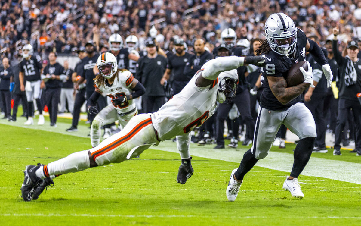 Raiders wide receiver DJ Turner (19) gets past a diving Cleveland Browns linebacker Jeremiah Ow ...