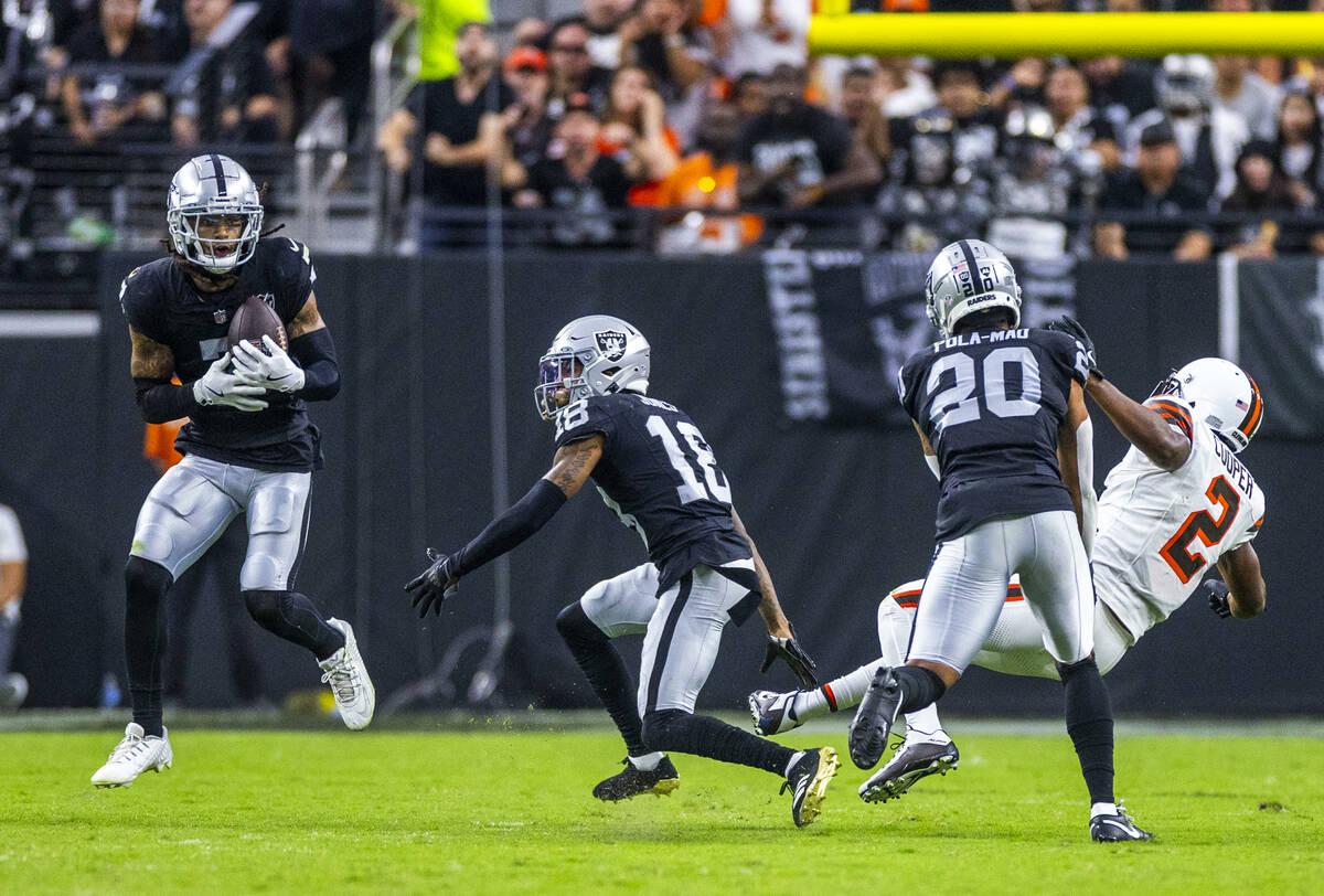 Raiders safety Tre'von Moehrig (7) looks in an interception as safety Isaiah Pola-Mao (20) puts ...