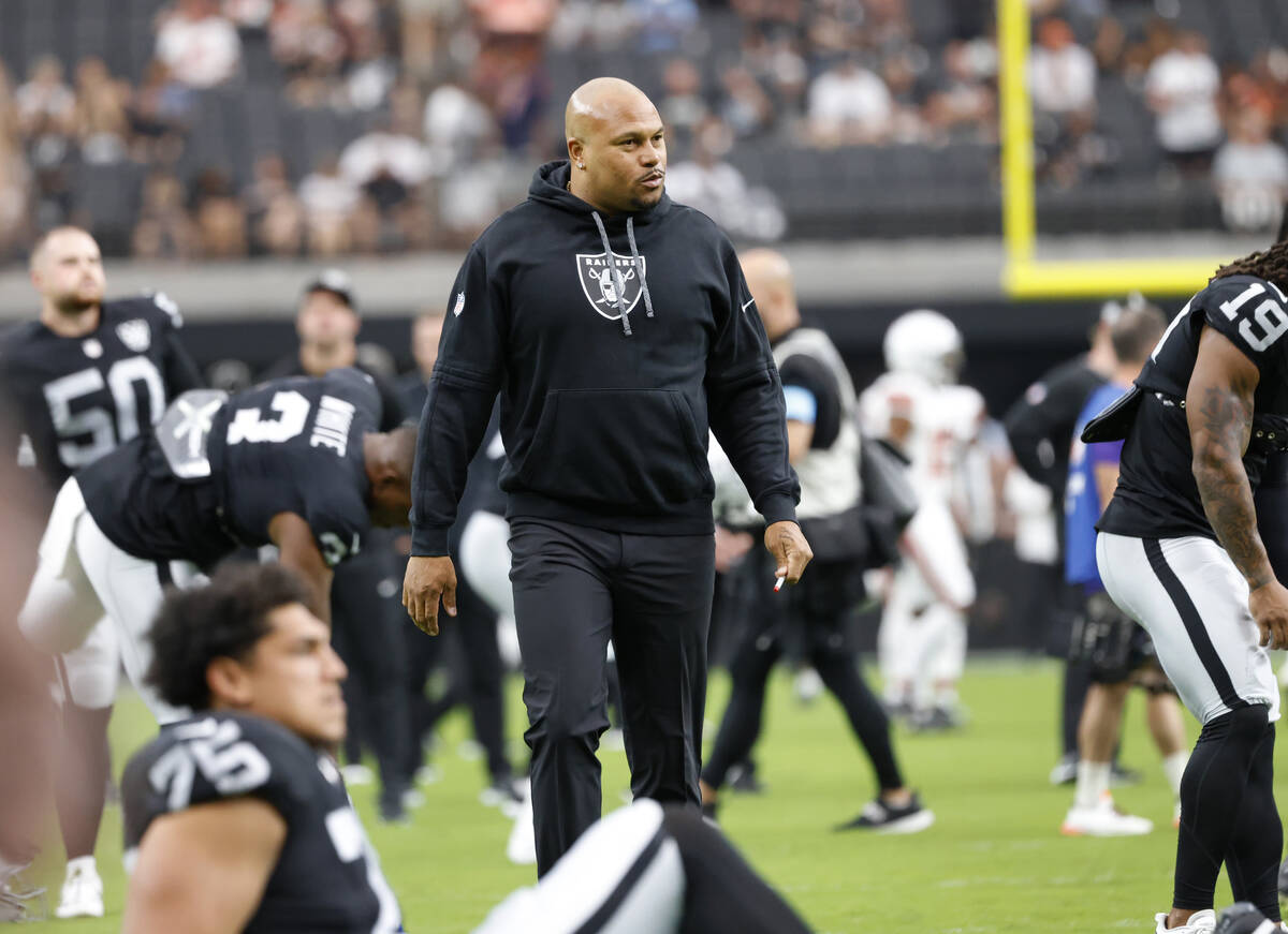 Raiders head coach watches as his team warms up before an NFL game against the Cleveland Browns ...