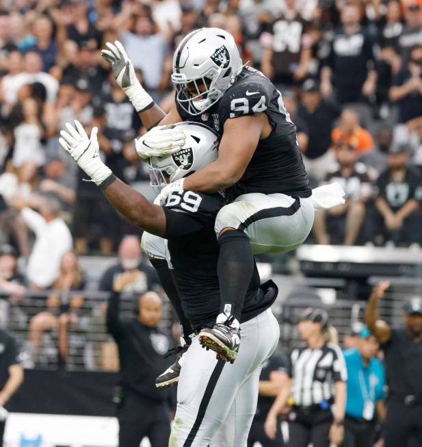 Raiders defensive tackle Adam Butler (69) and defensive tackle Christian Wilkins (94) celebrate ...