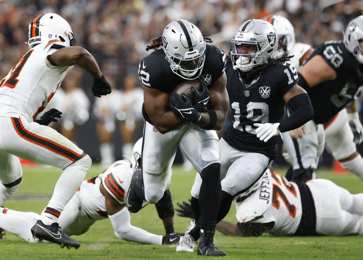 Raiders running back Alexander Mattison (22) runs past the Cleveland Browns defense during the ...