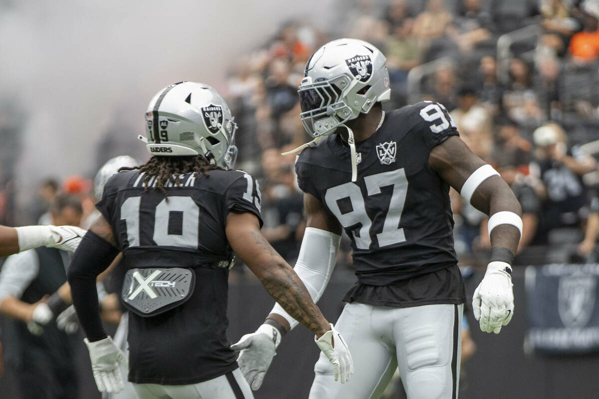 Raiders wide receiver DJ Turner (19) and defensive end Janarius Robinson (97) before an NFL gam ...