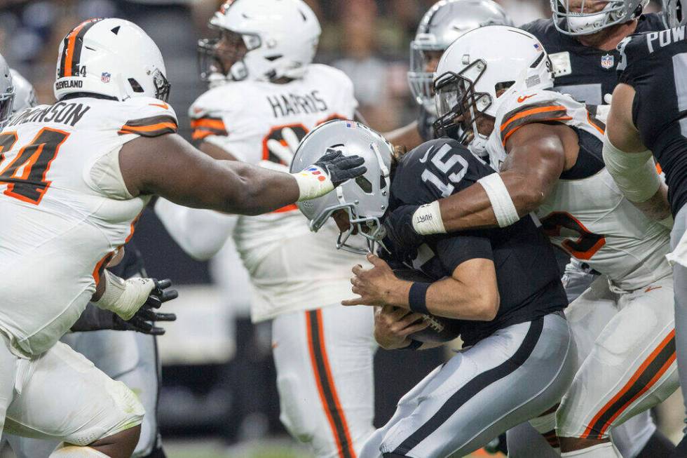 Raiders quarterback Gardner Minshew (15) is sacked by Cleveland Browns defensive end Myles Garr ...