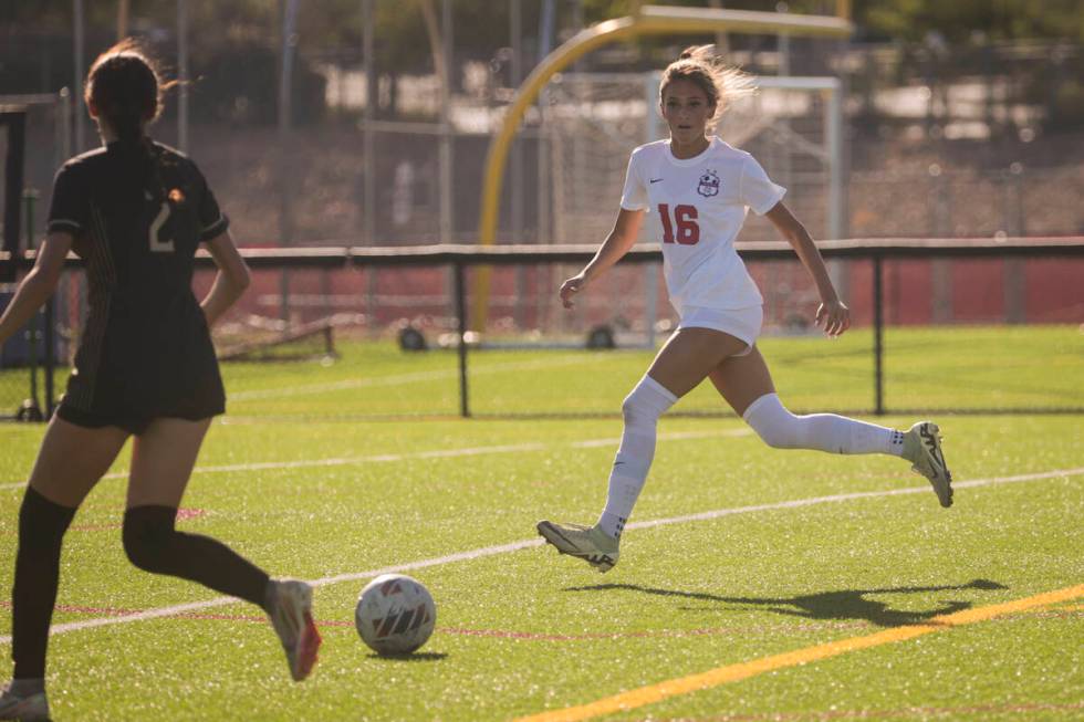 Coronado's Mia Schlachter (16) and Faith Lutheran's Elliott Lujuan (2) eye the ball during a so ...