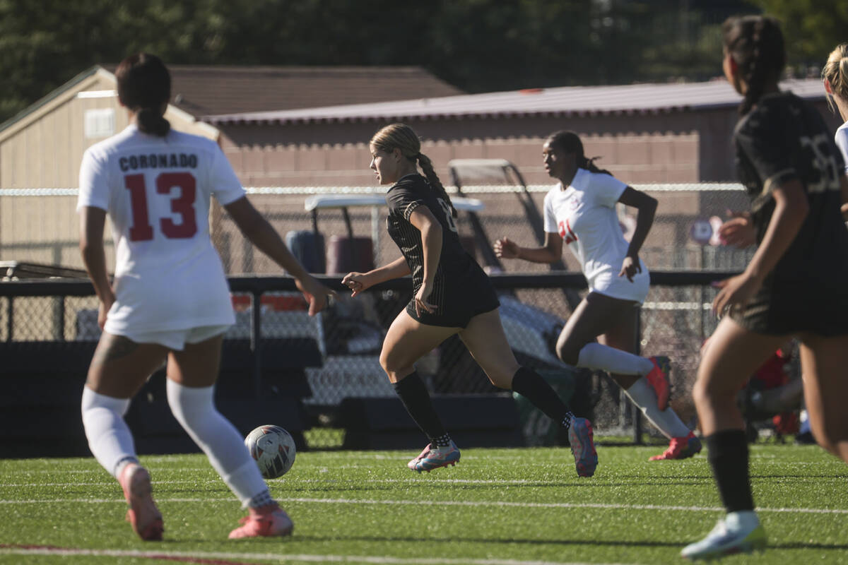 Faith Lutheran's Olivia Stark (8) brings the ball up the field against Coronado during a soccer ...