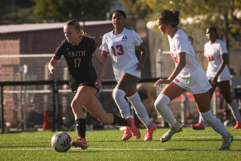 Faith Lutheran's Julia Anfinson (17) brings the ball up the field against Coronado during a soc ...