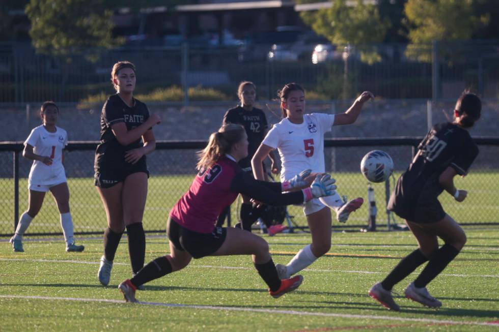 Coronado's Abby Obregon (5) kicks the ball in front of Faith Lutheran's goalkeeper Olivia Petty ...