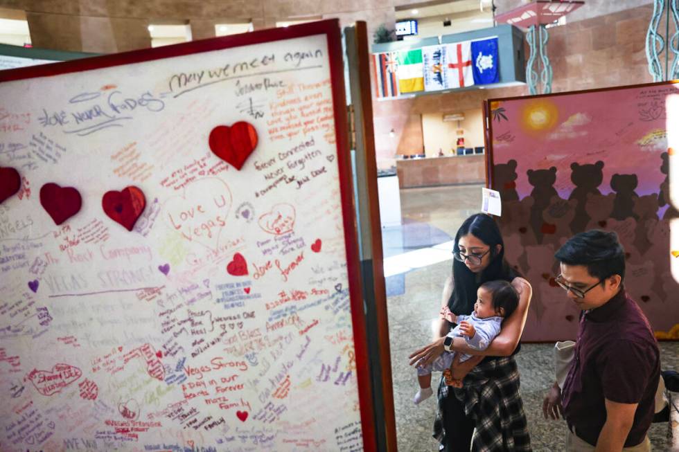 Joan Madriaga and her husband Alec Madriaga look at paintings on display with their daughter An ...