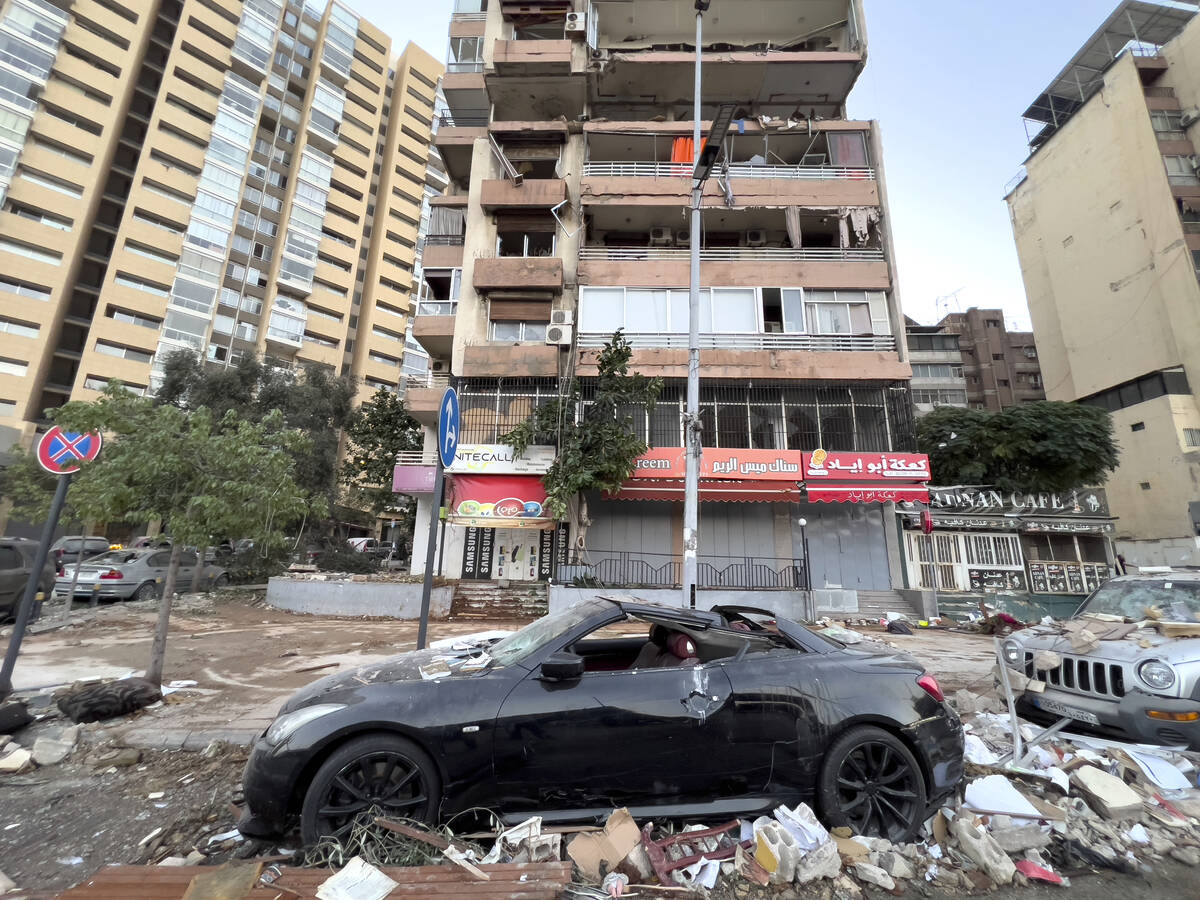 Damaged cars are parked in front of a building that was hit by an Israeli airstrike early Monda ...