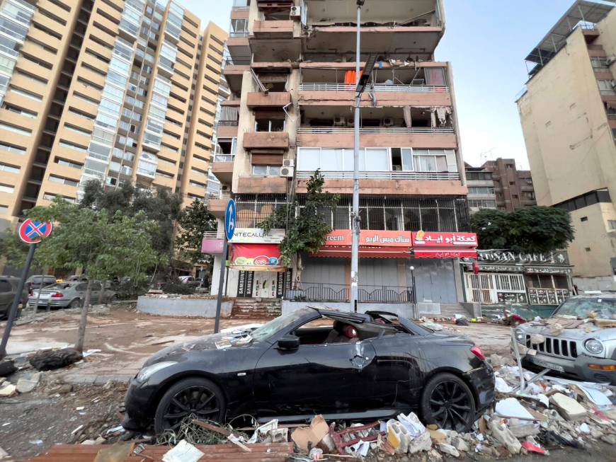 Damaged cars are parked in front of a building that was hit by an Israeli airstrike early Monda ...