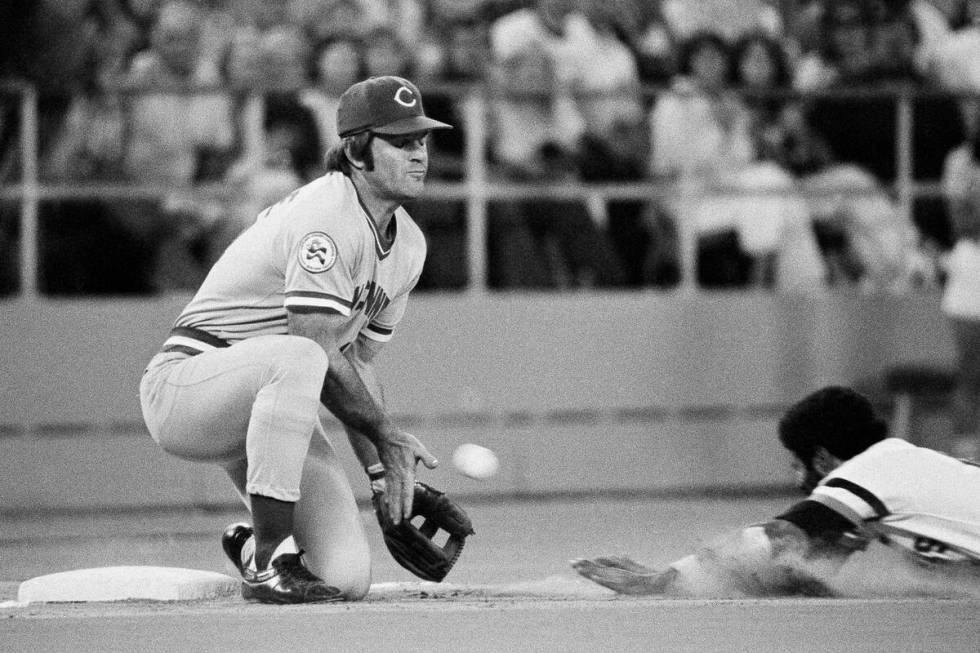 Cincinnati Reds third baseman Pete Rose, left, reaches for the throw from center field as Pirat ...