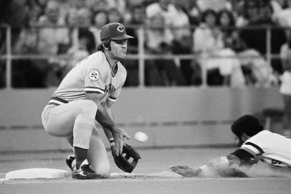 Cincinnati Reds third baseman Pete Rose, left, reaches for the throw from center field as Pirat ...