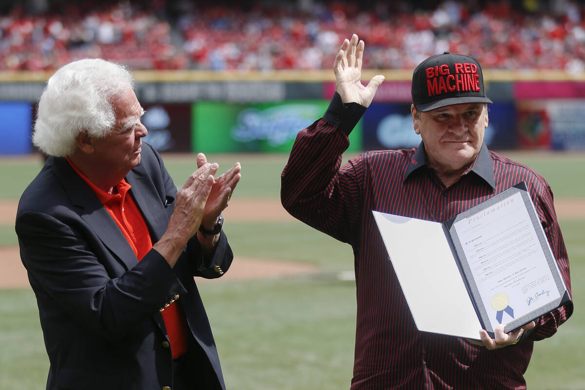 Former Cincinnati Reds player Pete Rose waves alongside Vice Mayor David Mann on the field at G ...