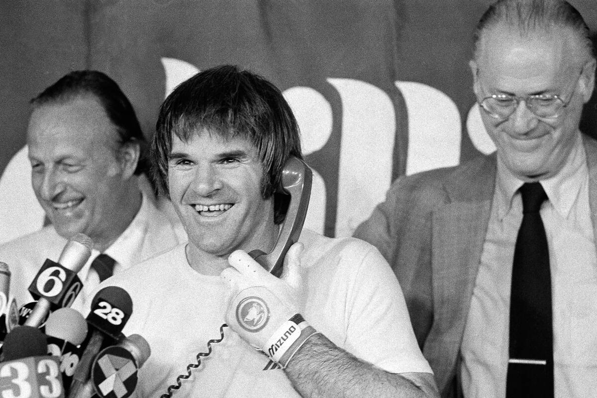 With Stan Musial behind him, Phillies Pete Rose talks on the telephone with President Reagan on ...