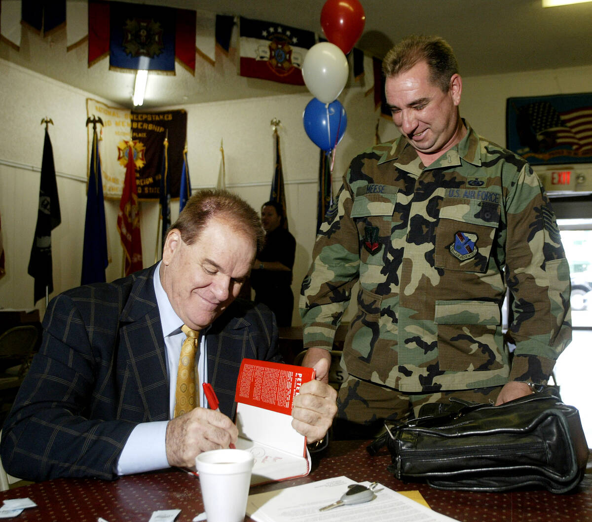 Former Major League Baseball player Pete Rose, left, signs an autograph for U.S. Air Force Tech ...