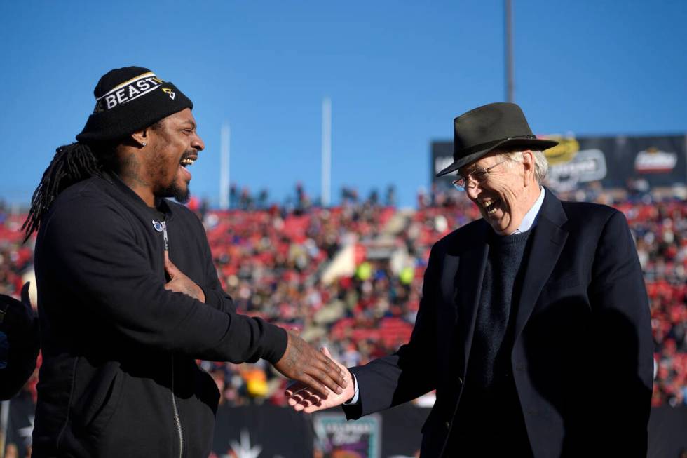 Former NFL star Marshawn Lynch and broadcaster Brent Musburger shake hands while being honored ...