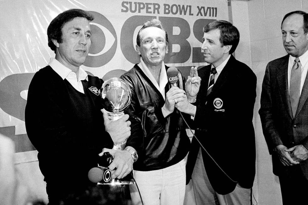 FILE - Los Angeles Raiders coach Tom Flores clutches the Super Bowl trophy as Raiders managing ...