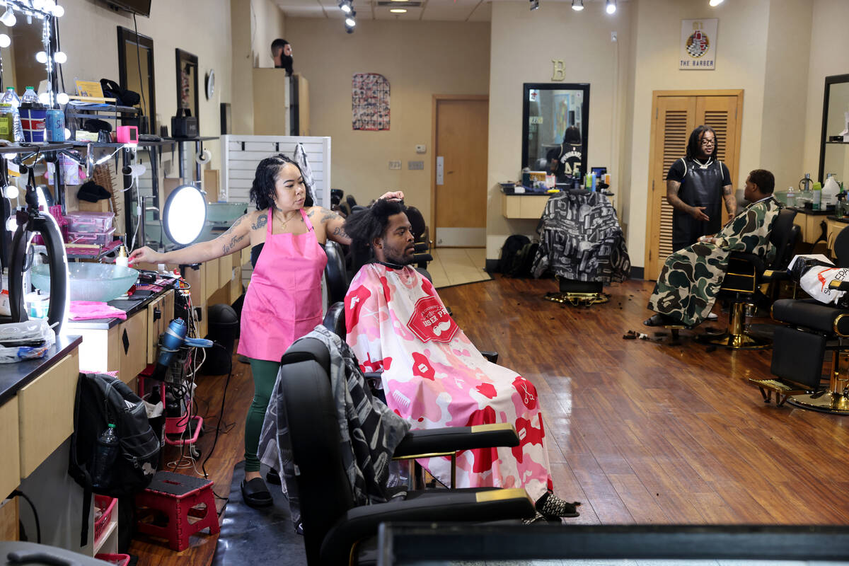 Leesah Khammany, a barber at A1 Barbershop, works with a client at the Boulevard Mall on Maryla ...