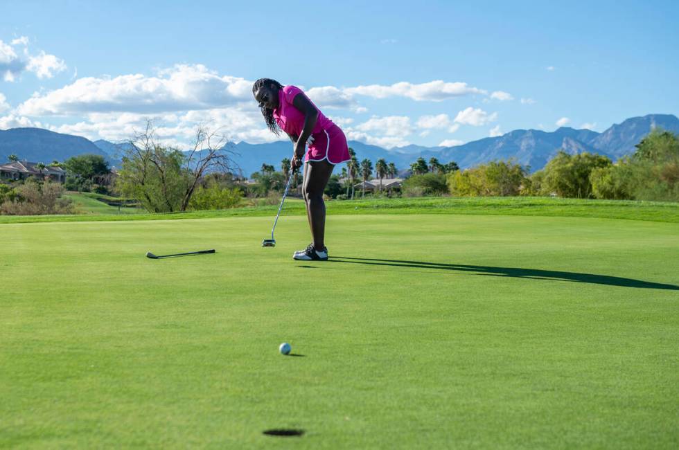 Faith Lutheran High School golfer Faith McKinney putts from the 13th hole during practice at th ...