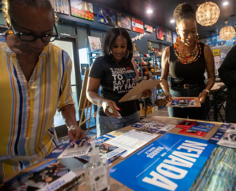 Shaunda Necole, center, grabs supplies during a canvassing and phone banking event for the Demo ...