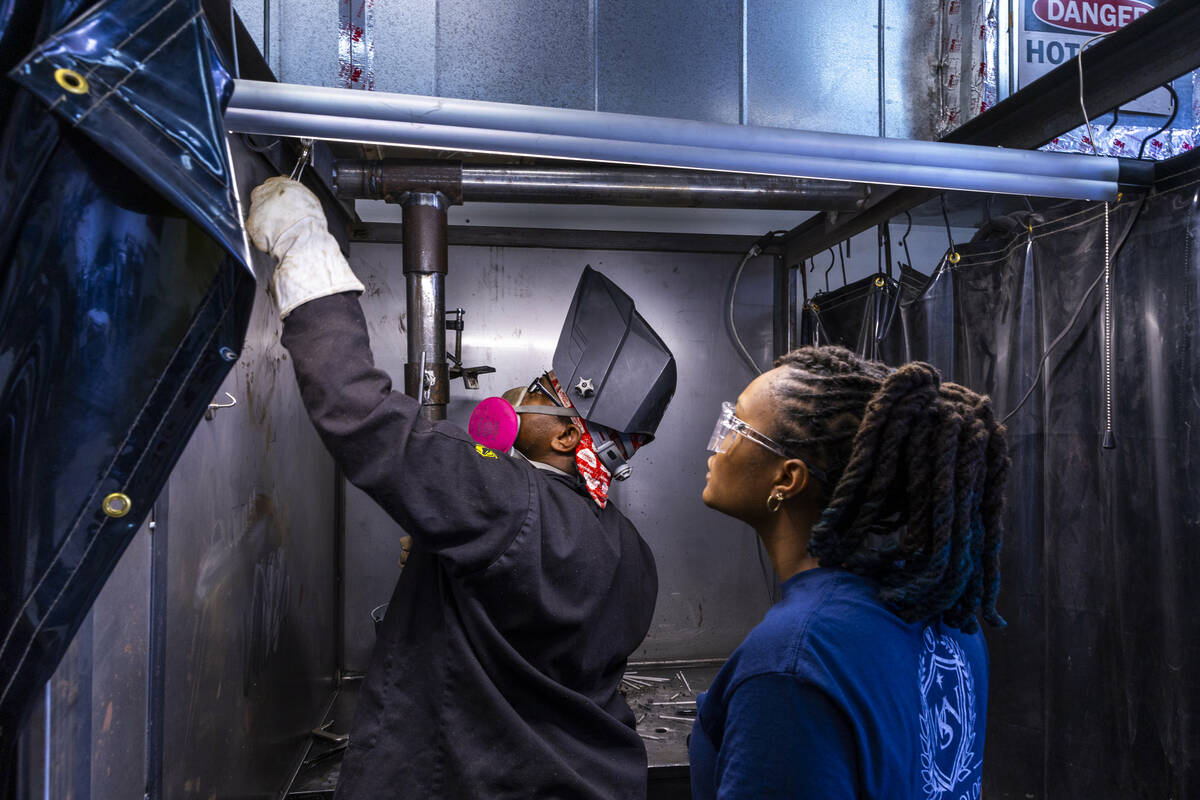 Graduate Pierre Leaks, left, prepares to weld as instructor Raven Berrian observes his set up a ...