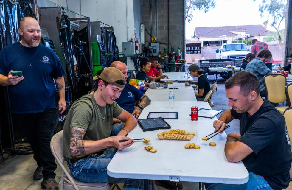 Founder Greg Gilbert, left, times particpants in a cookie stacking contest using chop sticks du ...