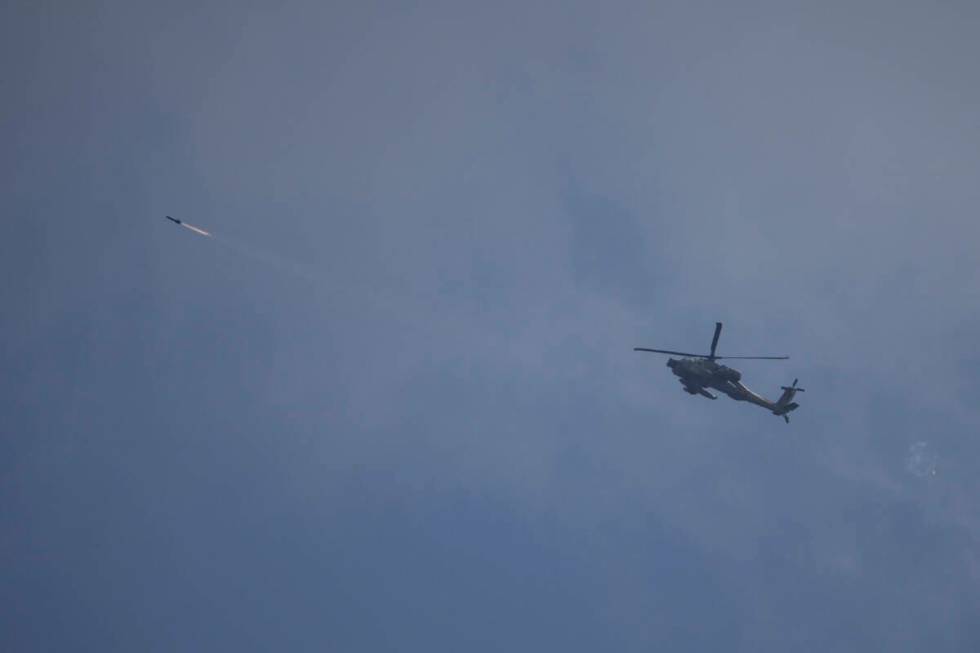 An Israeli Apache helicopter fires a missile towards southern Lebanon as seen from northern Isr ...