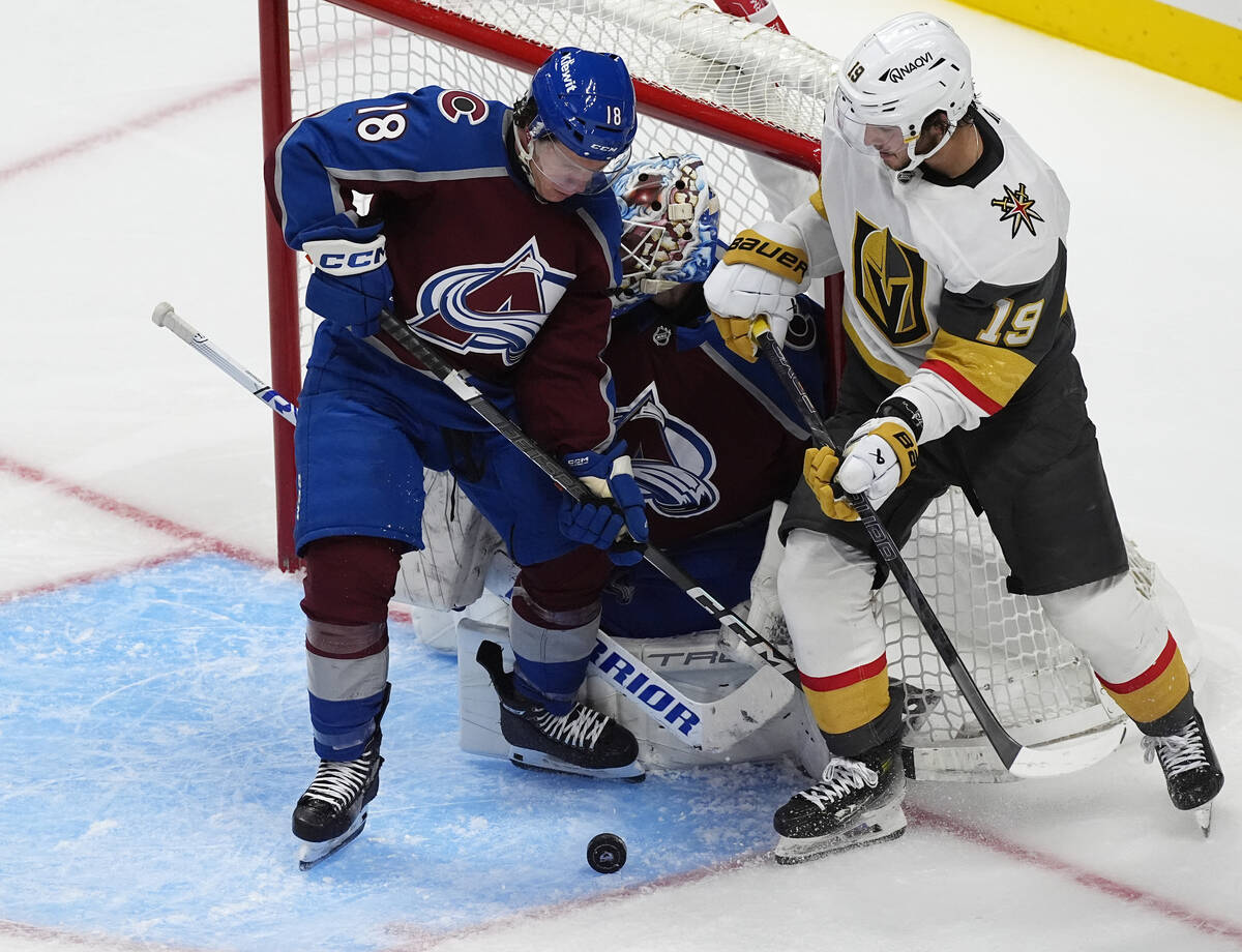 Colorado Avalanche defenseman Jack Ahcan, front left, tries to clear the puck from in front of ...