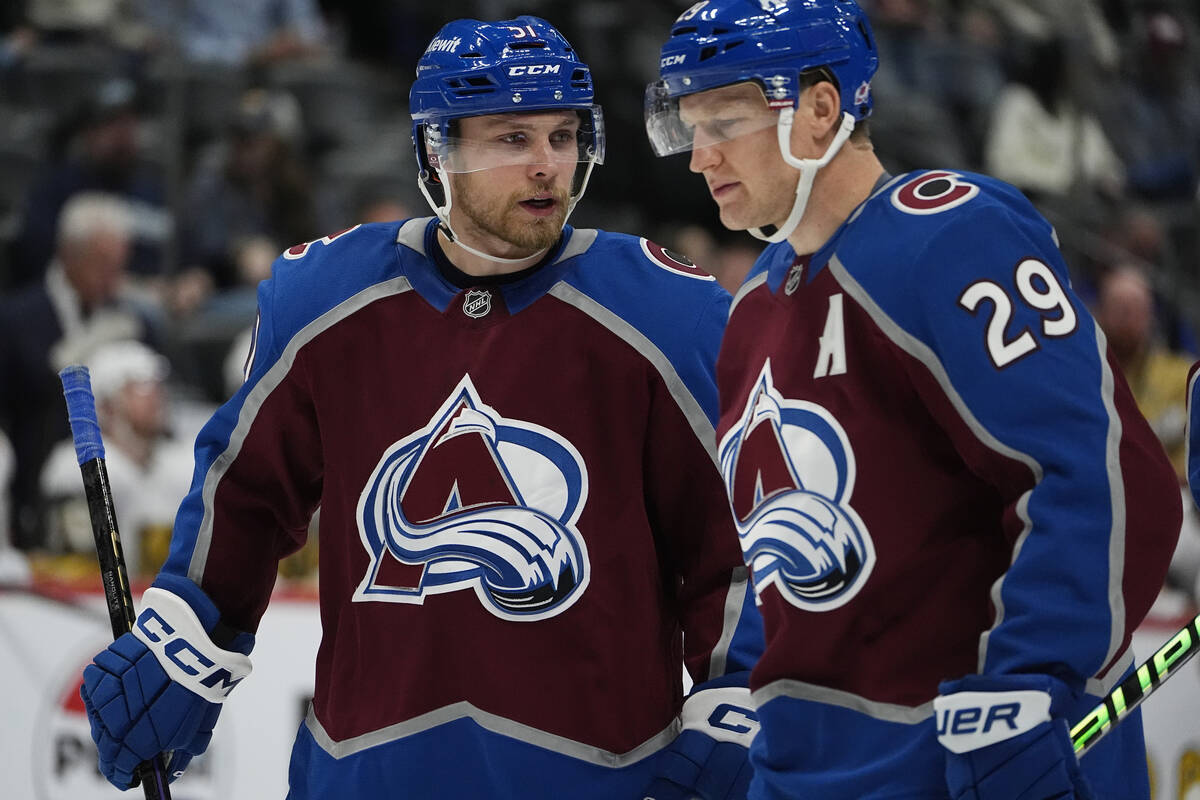 Colorado Avalanche right wing Nikolai Kovalenko, left, confers with center Nathan MacKinnon in ...