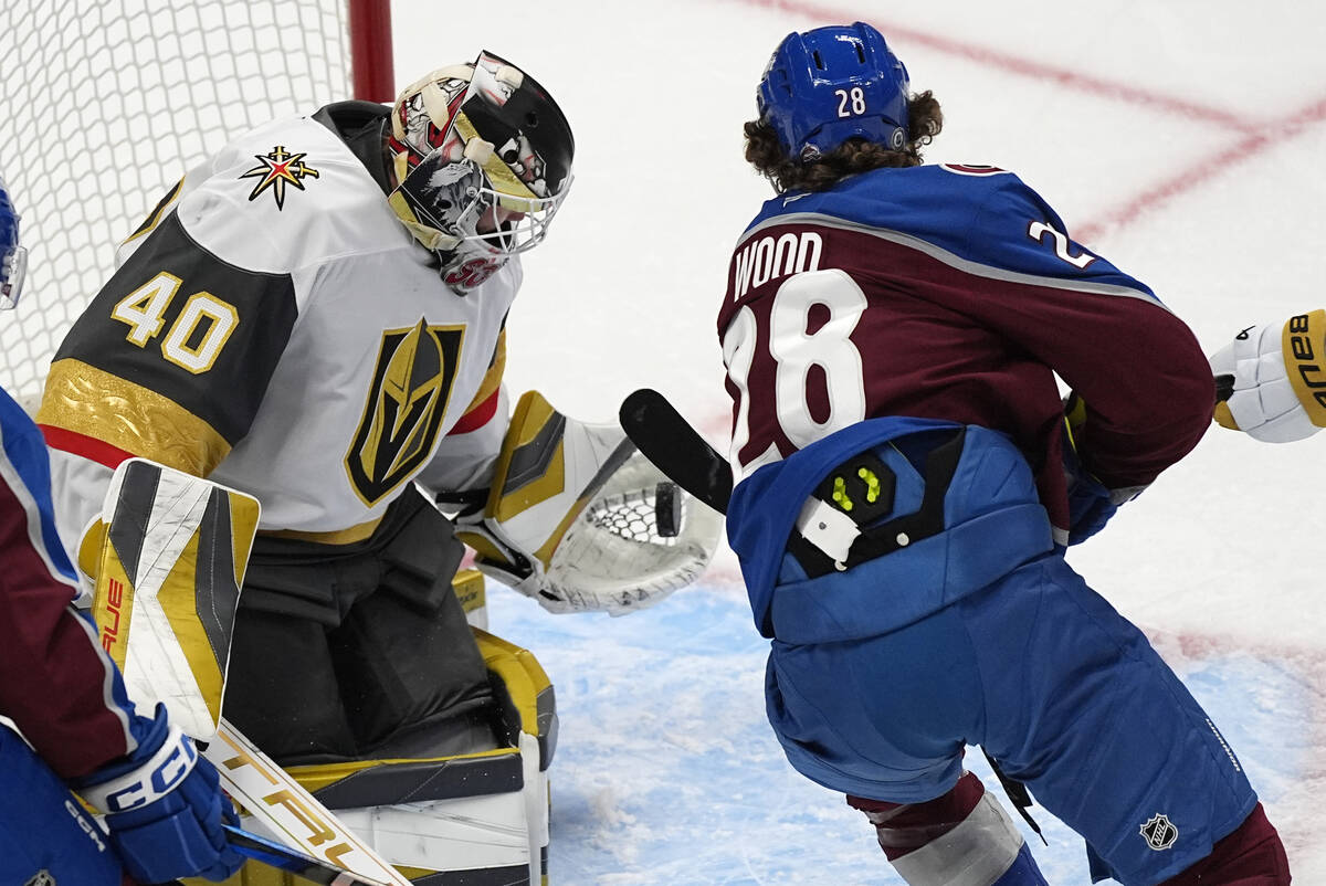 Vegas Golden Knights goalie Akira Schmid, left, makes a glove save of a shot from Colorado Aval ...