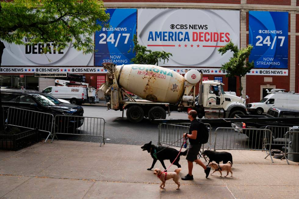 A person walks dogs a day ahead of a CBS News vice presidential debate between Republican vice ...