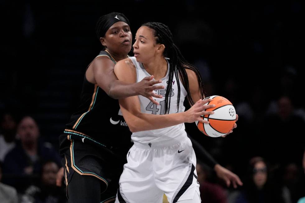 New York Liberty's Jonquel Jones, left, defends Las Vegas Aces' Kiah Stokes during the first ha ...