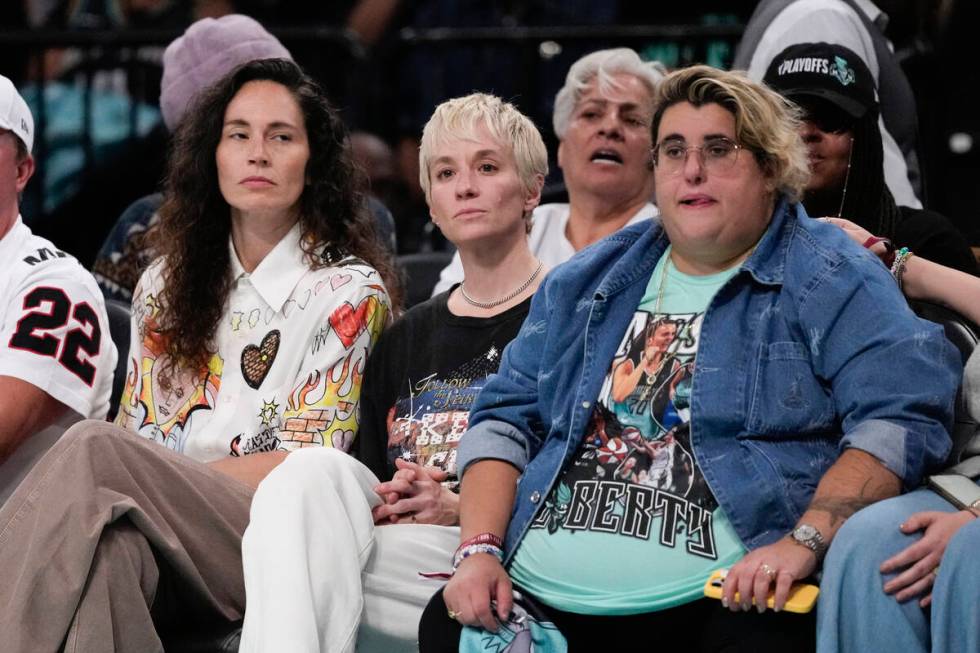 Megan Rapinoe, center, and Sue Bird, left, watch during the second half of a WNBA basketball se ...