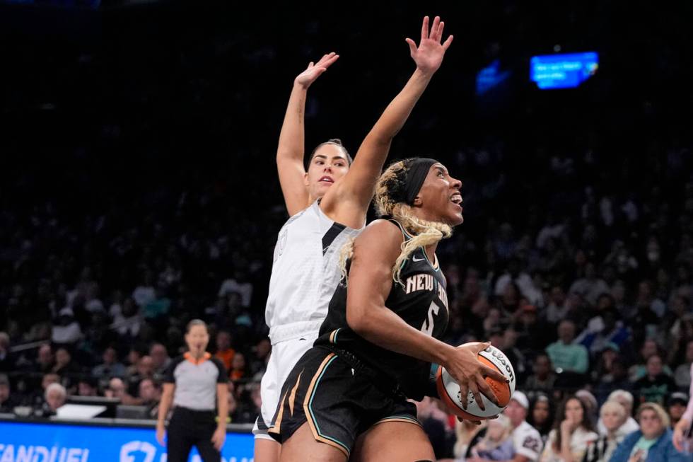 New York Liberty's Kayla Thornton (5) drives past Las Vegas Aces' Kelsey Plum (10) during the f ...