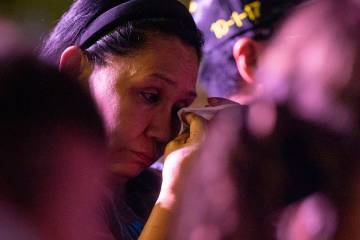 A mourner uses a tissue during the candlelight vigil to remember those who perished during the ...