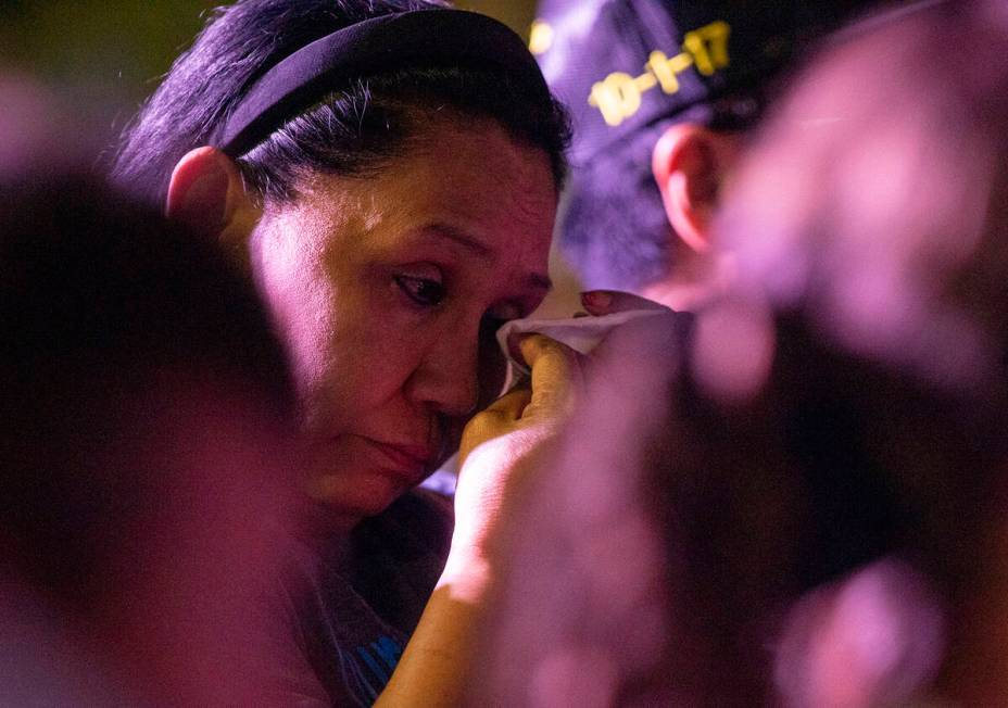 A mourner uses a tissue during the candlelight vigil to remember those who perished during the ...