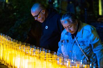 File - People stand around lit candles after Mayor Carolyn Goodman and David Riggleman, Las Veg ...